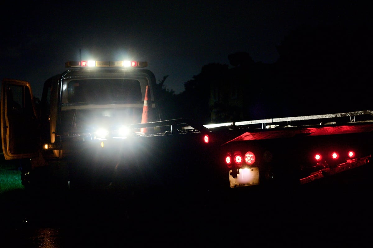 Heavy wrecker with work lights on at night