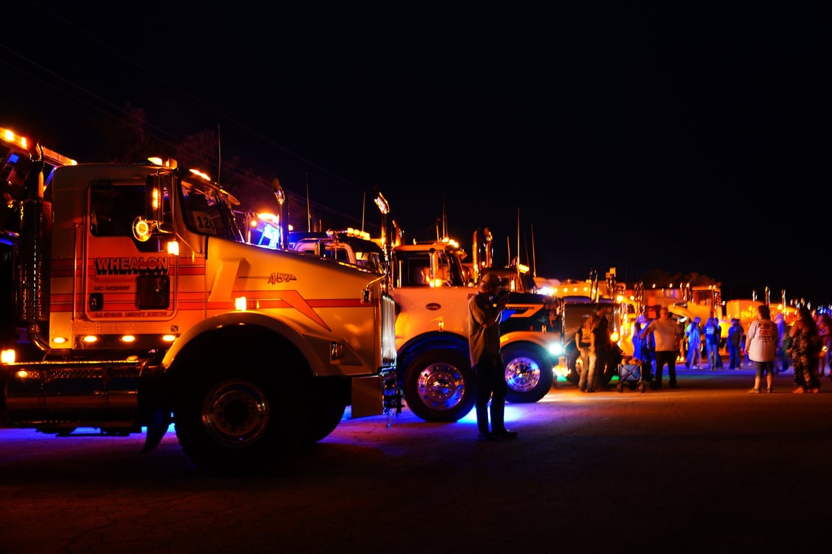 Tow trucks glowing with caution lights at night